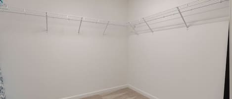 A room with a beige carpet, white walls, and a metal drying rack.