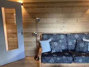 Eine Holzwand mit einer Tür und einem Sofa mit gemusterten Kissen.