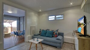 Uma sala de estar moderna com sofá, mesa de centro e televisão.