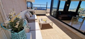 Un espace de vie extérieur moderne comprenant un canapé, une table basse et un jacuzzi.
