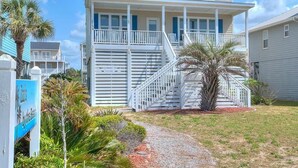 A two-story beachfront house with a balcony and a staircase leading to the second floor. - 2nd Row Oceanview Home with Private Pool, Zzzs by the Beach (Oak Island)