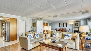A living room with two sofas, a coffee table, and a dining area with a lamp. - DAILY ACTIVITIES & LINENS INCLUDED! 3BR, 2BA Condo with a Large Balcony. Great mid-town location! (Ocean City)