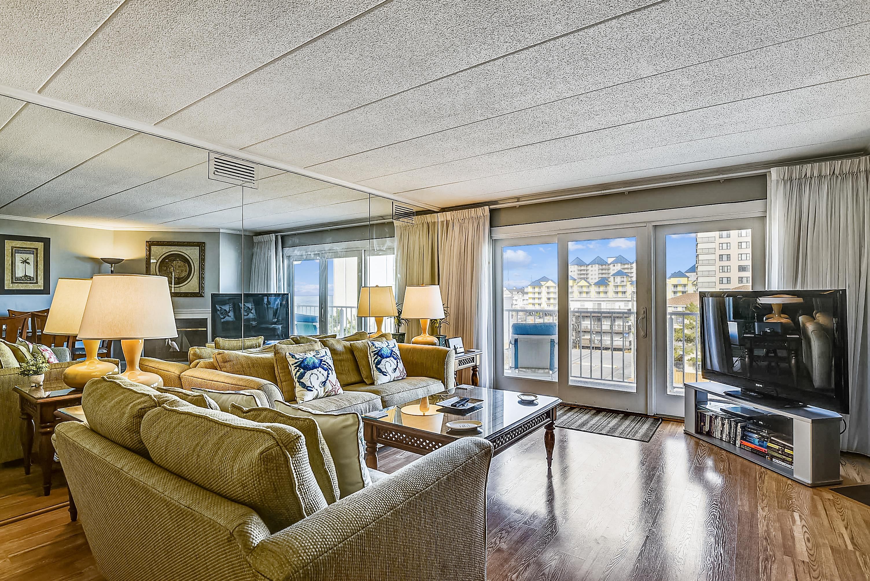A spacious living room with a large sofa set, a coffee table, and a television.