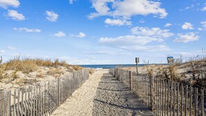 A sandy pathway leading to the beach, flanked by wooden fences, under a clear sky. - DAILY ACTIVITIES & LINENS INCLUDED! 3BR, 2BA Condo with a Large Balcony. Great mid-town location! (Ocean City)