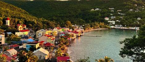 A coastal town with colorful buildings, a dock, and a clear view of the sea.