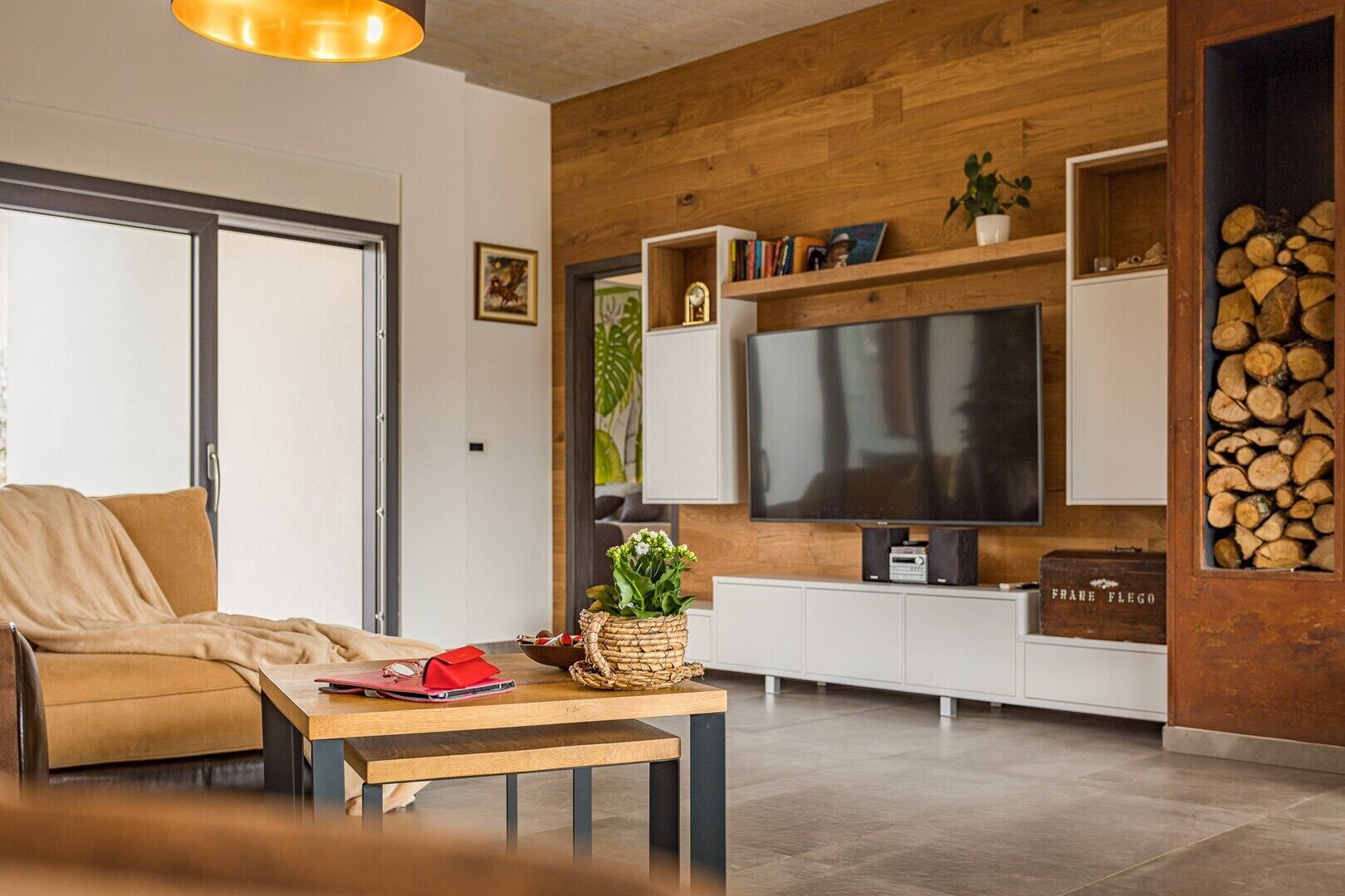 A modern living room with a sofa, a coffee table, a TV, and a fireplace.