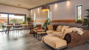 Uma sala de estar moderna com um sofá seccional, área de jantar e grandes janelas.
