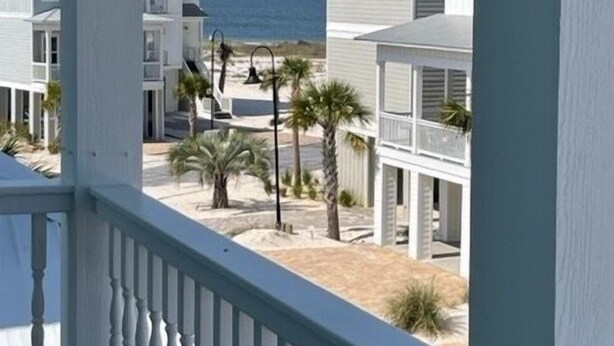 A coastal view from a balcony with a railing, overlooking a beach and several white buildings with balconies. - Tequila Sunrise 4 Bedroom Home by RedAwning (Navarre)