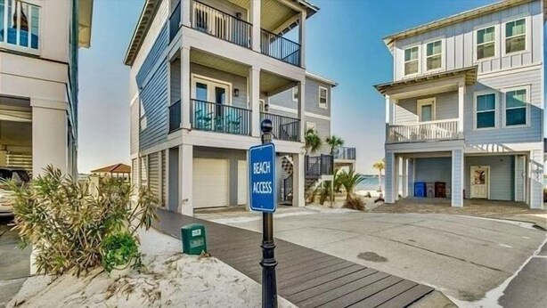 Edificio residencial frente a la playa, con un letrero que indica acceso a la playa.
