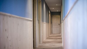 A hallway with wooden flooring and walls painted in blue and white.