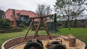 A playground with a tire swing, tire steps, and a rope ladder.