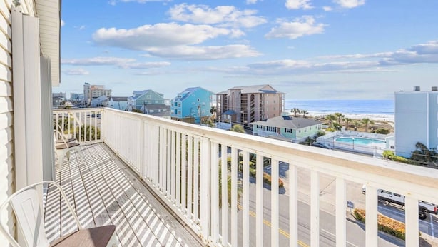 A balcony with a view of a beach and buildings.