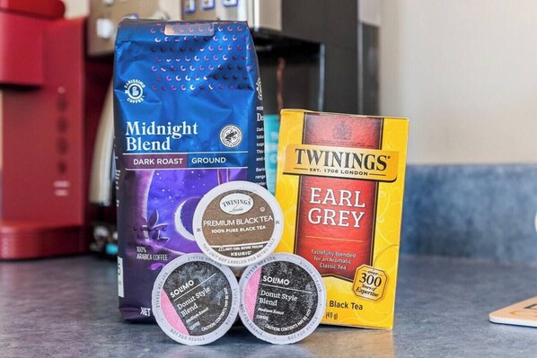 A coffee bag, a box of Earl Grey tea, and two containers of black tea.