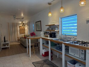 A compact kitchen with a dining area, a coffee maker, a microwave, and a window with blinds. - Pirate's Cove STJ š“āā ļø15 minute walk to town and newly remodeled king 1 bdrm, ACšš“āā ļø (Cruz Bay)