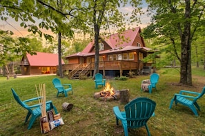 Een chalet met een rood dak, terras en vuurplaats.