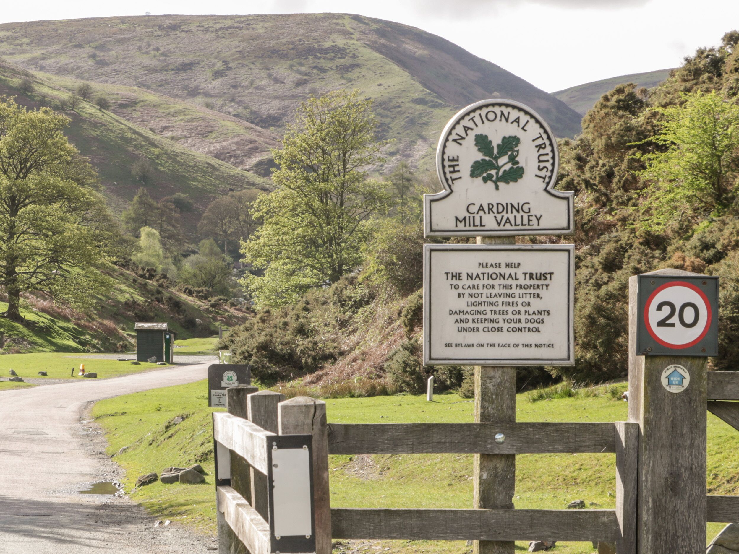 En skylt för organisationen The National Trust vid Carding Mill Valley, tillsammans med en skylt som anger hastighetsbegränsningen 20.
