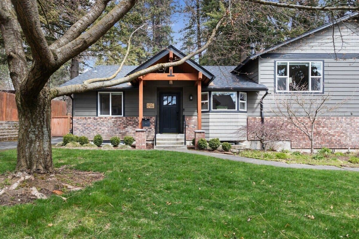 A two-story house with a brick facade, a dark front door, and a small porch.