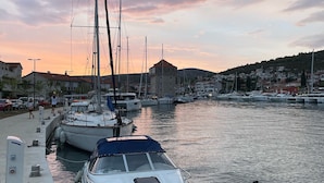 A marina with boats docked, a clear sky, and a distant building.