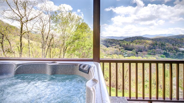 Un jacuzzi con vistas a un paisaje boscoso y montañas.