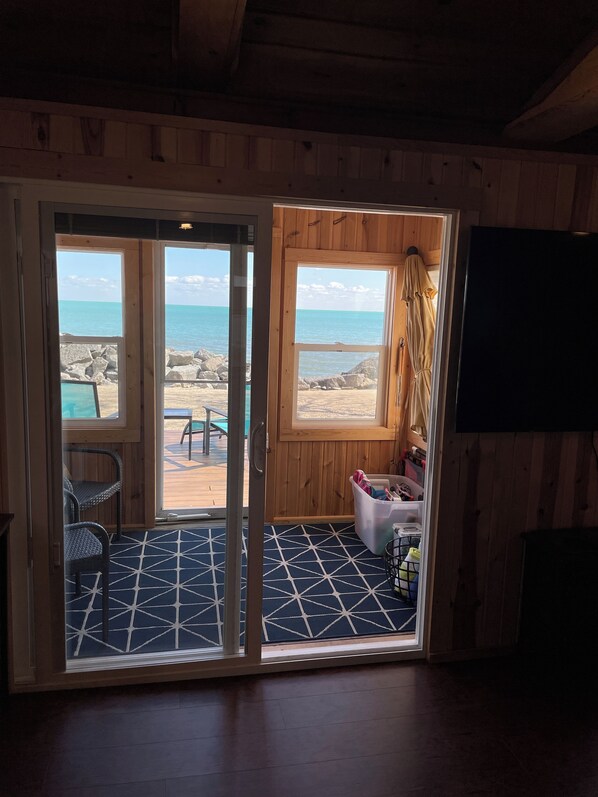 Ein Holzinnenraum mit Blick auf den Strand durch Glasüren.