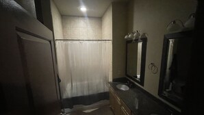 A bathroom with a shower, two sinks, a mirror, and a toilet. - Entire Apt • 1br w/private balcony SouthWest Houston (Houston)