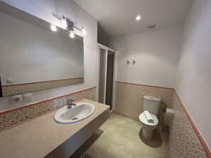 Une salle de bain avec un lavabo, des toilettes et un miroir.