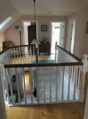 Cozy loft-style room with a crib and door to adjacent space.