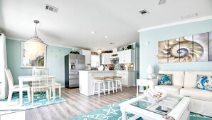 Une cuisine moderne avec des meubles blancs, un îlot central et des tabourets de bar.