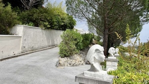 A pathway with stone sculptures and greenery. - House with pool next to lake Saint-Cassien in the Esterel valleys. 20 min Cannes (Montauroux)