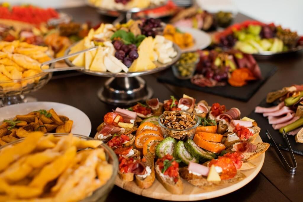 A variety of food items on a table, including cheese, fruits, and bread.