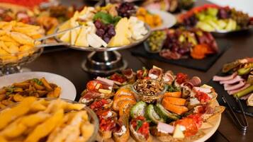A variety of food items on a table, including cheese, fruits, and bread.