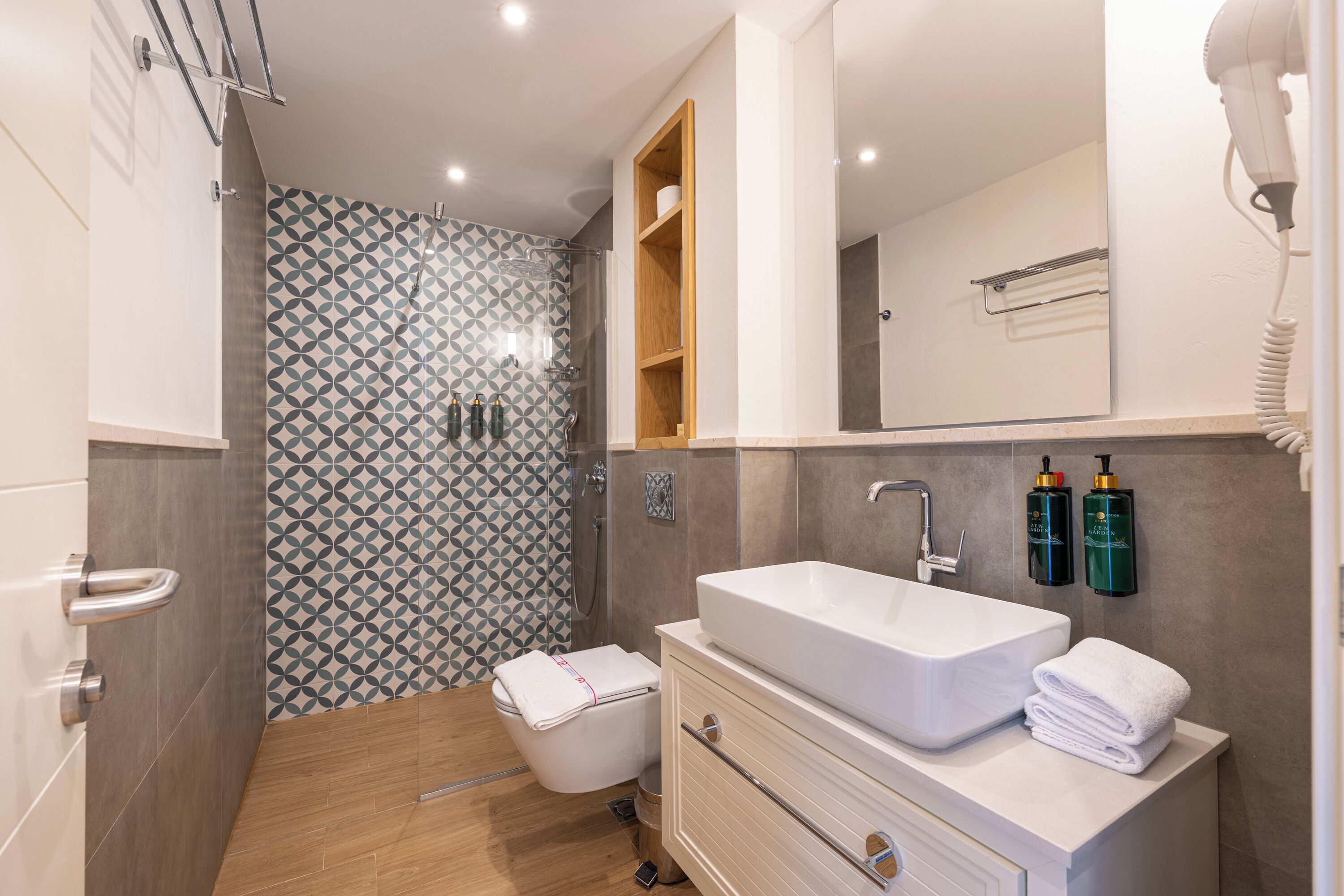 A modern bathroom with a large sink, toilet, and shower.
