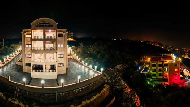 Un hotel de varios pisos con un patio central y una piscina.