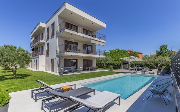 A modern multi-story building with a swimming pool, outdoor seating, and a well-maintained lawn. - Caci-A1 with Pool - istriensonne 0712 (Medulin)