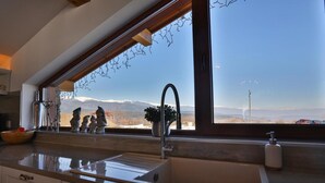 A kitchen with a large window, a sink, and decorative items.