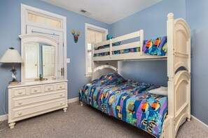 A bedroom with a bunk bed, a dresser, a mirror, and a window with blinds. - Mini Weeks Stays Available Sunset Island 38 Sunset (Ocean City)