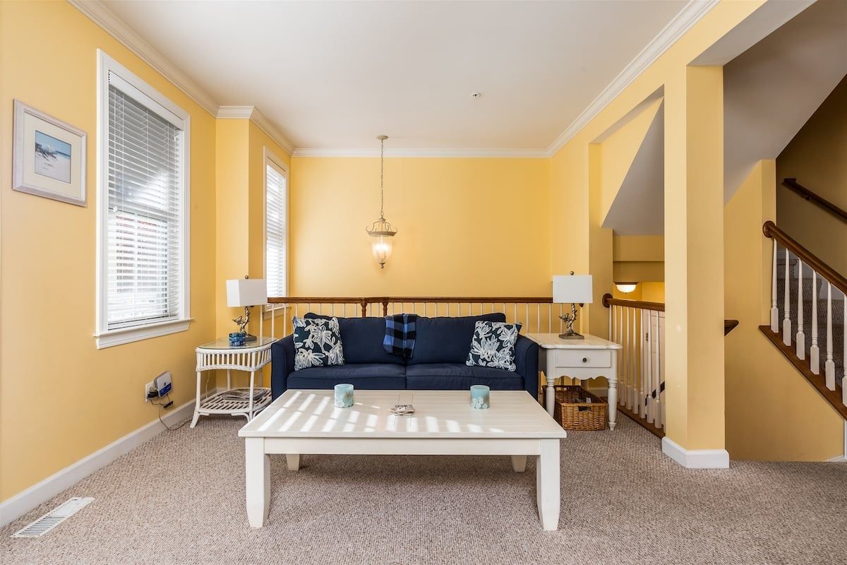 A living room with a sofa, coffee table, and two lamps.