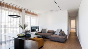 A modern living room with a sectional sofa, a coffee table, and a flat-screen TV.