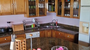 Una cocina con encimeras de granito, armarios de madera, horno empotrado y dispensador de agua.