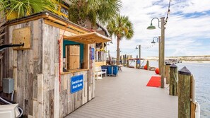 Une station d’embarquement pour la navette de plage, construite en bois, avec une pancarte indiquant « Navette pour Emerald Grande Beach ».
