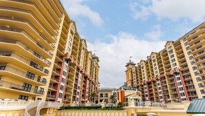 A multi-story hotel with balconies, a central courtyard, and a distinctive architectural design. - Club Wyndham Emerald Grande - 1 Bedroom (Destin)