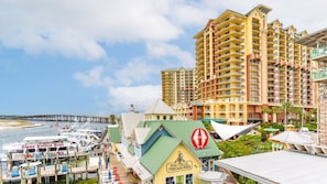 Un hotel costero con varios edificios altos, una marina con barcos y un edificio destacado con temática náutica.