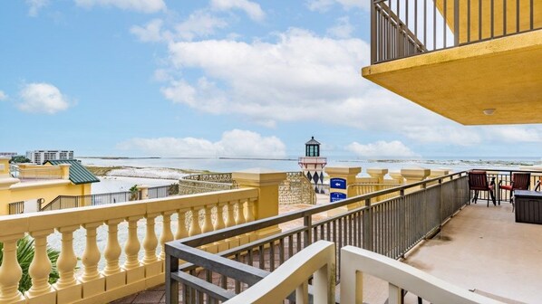 Uma varanda com vista para a praia e um farol.