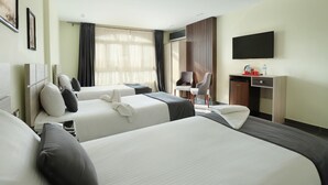 A hotel room with two beds, a desk, a chair, a television, and a window with curtains. - Brothers Pyramids View (Giza)
