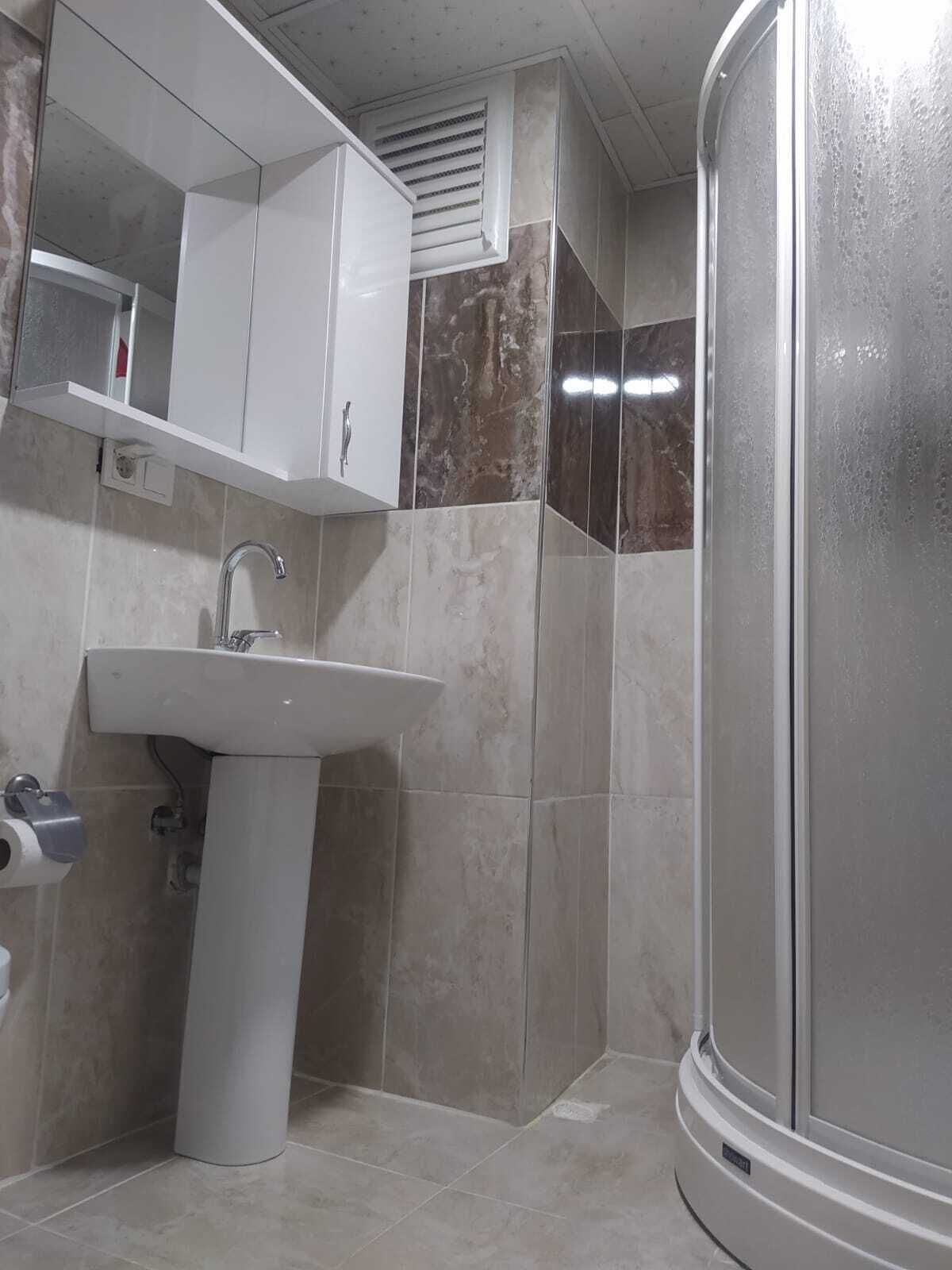 Une salle de bain équipée d’un lavabo, d’un miroir et d’une cabine de douche.