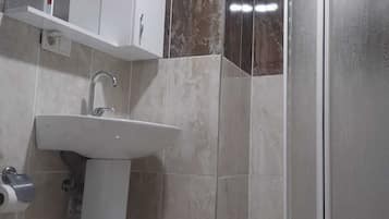 Une salle de bain équipée d’un lavabo, d’un miroir et d’une cabine de douche.
