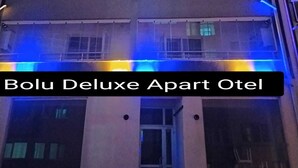 Un edifici de diverses plantes amb balcons i un cartell amb la indicació "Bolu Deluxe Apart Otel".