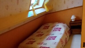 A small bedroom with a single bed, a nightstand, a lamp, and a window with curtains. - Apartment at the foot of DEAUVILLE/TROUVILLE (Touques)