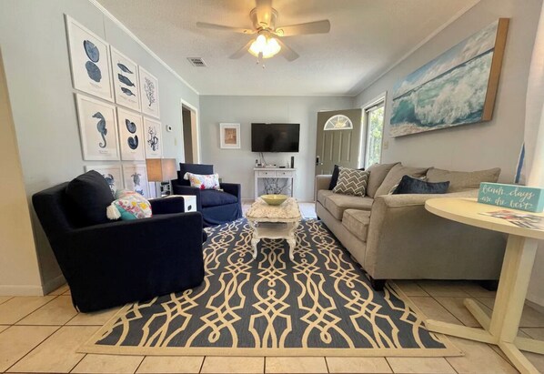 A living room with a ceiling fan, a television, and a coffee table.