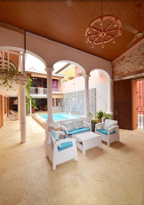A spacious indoor area with a pool, white furniture, and a wooden ceiling. - 7CA2-1 CASA DE LUJO EN CARTAGENA (Cartagena)